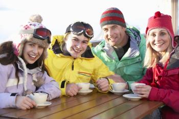 Teenage Family Enjoying Hot Drink In Caf At Ski Resort