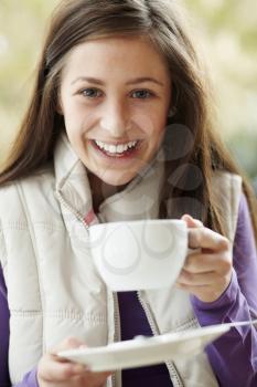 Teenage Girl In Outdoor Caf With Hot Drink  Wearing Winter Clothes