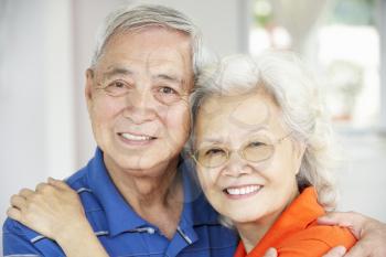 Senior Chinese Couple Relaxing On Sofa At Home
