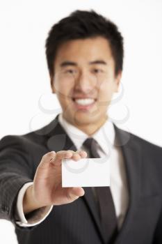 Studio Portrait Of Chinese Businessman Offering Business Card
