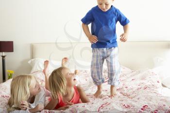 Children Bouncing On Bed