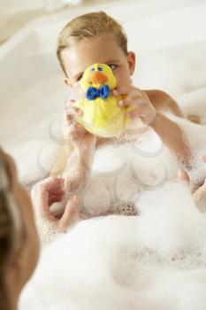 Mother And Daughter Relaxing In Bubble Filled Bath