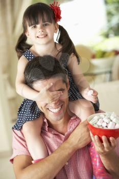 Father Giving Daughter Ride On Shoulders Indoors Whilst Eating Marshmallows