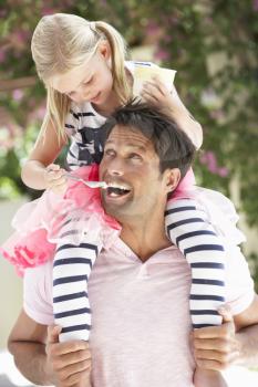 Father Giving Daughter Ride On Shoulders Whilst Being Fed Ice Cream
