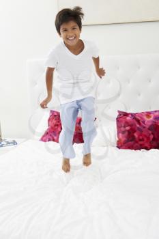 Boy Jumping On Bed Wearing Pajamas
