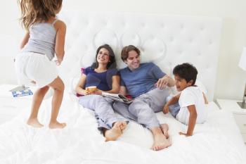 Children Jumping On Parents Bed Wearing Pajamas