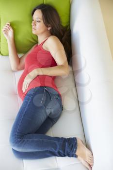 Overhead View Of Pregnant Woman Sleeping On Sofa