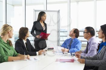Businesswoman Conducting Meeting In Boardroom