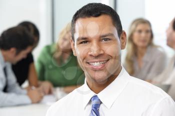 Portrait Of Businessman Sitting At Boardroom Table