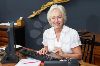 Hotel Receptionist Working At Computer
