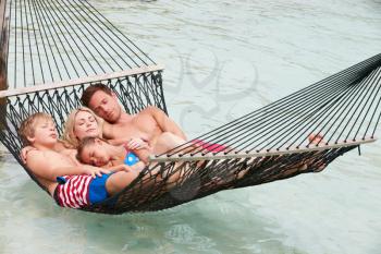 Family Relaxing In Beach Hammock