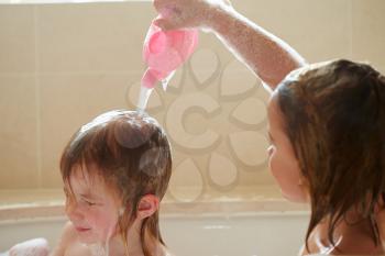 Two Girls Sharing Bubble Bath And Washing Hair