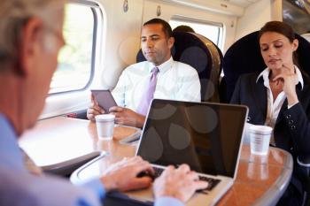 Businessman Commuting To Work On Train And Using Laptop