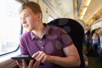 Young Man Reading E Book On Train Journey