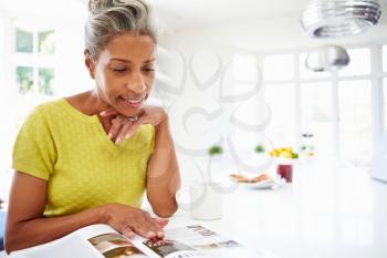 Woman Eating Breakfast And Reading Magazine