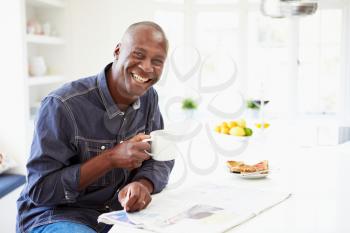 African American Man Eating Breakfast And Reading Newspaper