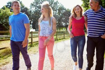 Family With Teenage Children Walking In Countryside