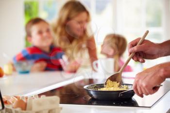 Close Up Of Father Preparing Family Breakfast In Kitchen