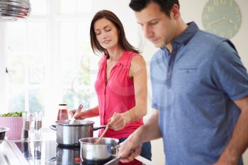 Hispanic Couple Cooking Meal At Home Together