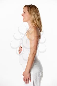 Studio Portrait Of 4 months Pregnant Woman Wearing White