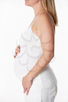 Close Up Studio Portrait Of 5 months Pregnant Woman Wearing White