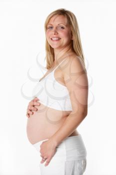 Studio Portrait Of 5 months Pregnant Woman Wearing White