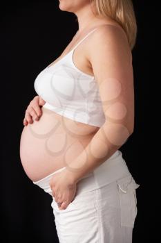 Close Up Portrait Of 6 months Pregnant Woman On Black Background