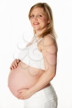 Studio Portrait Of 8 Months Pregnant Woman Wearing White