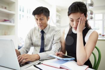 Worried Asian Couple Looking At Personal Finances