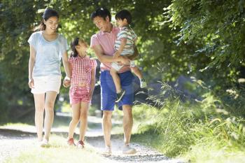 Asian Family Enjoying Walk In Countryside