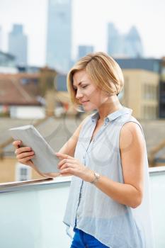 Woman On Roof Terrace Using Digital Tablet