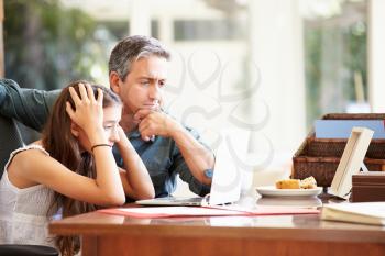 Father Helping Stressed Teenage Daughter Looking At Laptop