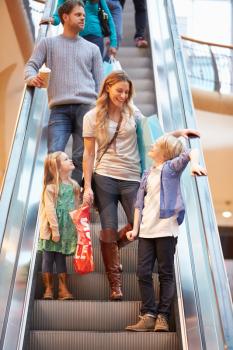 Mother And Children On Escalator In Shopping Mall