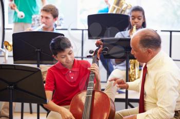 Boy Learning To Play Cello In High School Orchestra