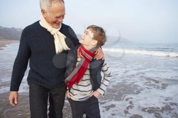 Grandfather And Grandson Walking On Winter Beach