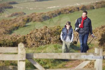 Father And Son With Dog Walking Along Coastal Path