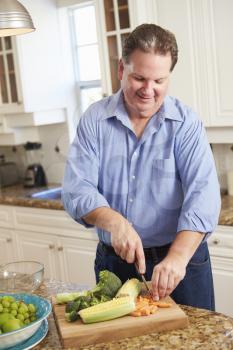 Overweight Man Preparing Vegetables in Kitchen
