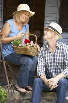 Senior couple sitting on veranda with flowers