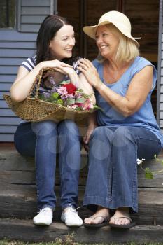 Adult mother and daughter sitting on veranda