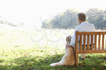 Senior man sitting outdoors with dog