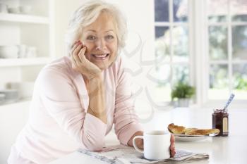 Retired woman eating breakfast