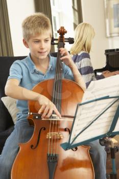 Boy and girl playing cello and  piano at home
