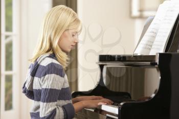 Girl playing grand piano at home
