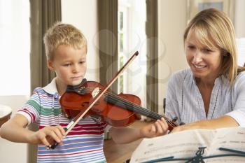 Young boy playing violin in music lesson