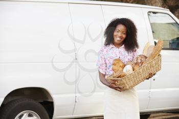 Female Baker Delivering Bread Standing In Front Of Van