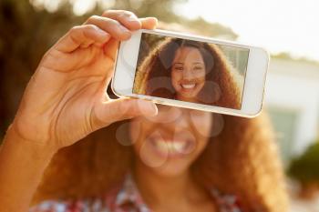 Woman On Holiday Taking Selfie With Mobile Phone