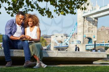Couple Using Digital Tablet With Tower Bridge In Background