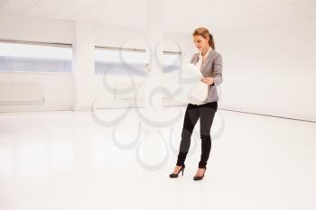 Female Architect Planning Layout Of Empty Office Space