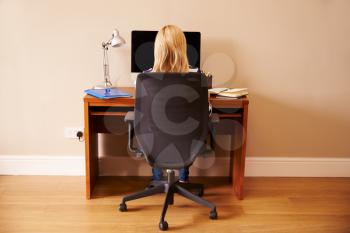 Woman Sitting At Desk Working At Computer In Home Office