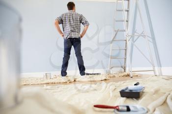 Man Decorating Nursery For New Baby